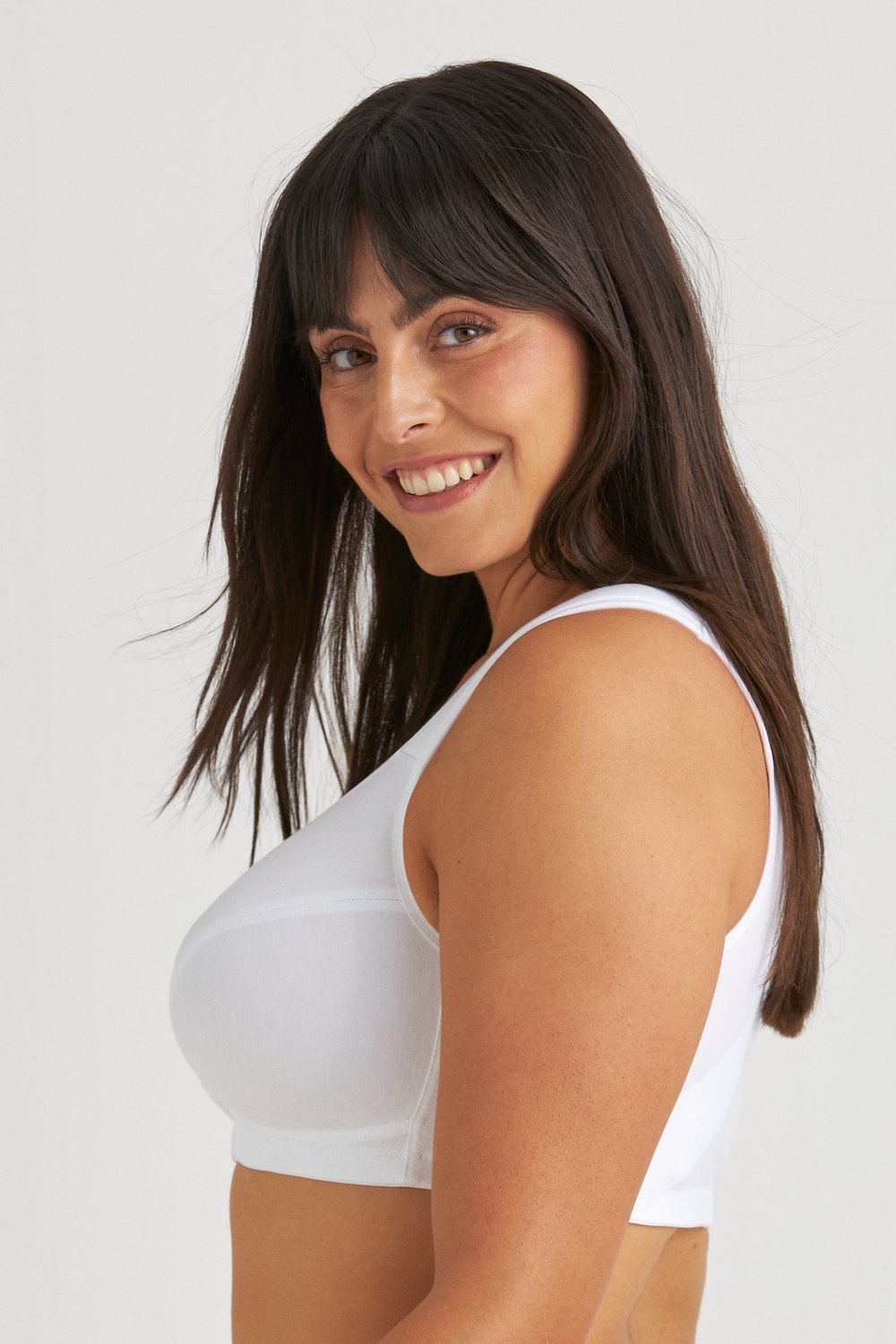 Vue de profil d'une femme souriante portant le soutien-gorge sans armatures Cotton X-back blanc Miss Mary.