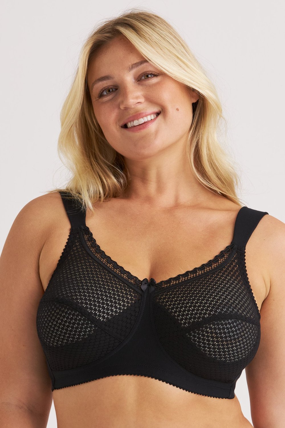 Femme souriante portant le soutien-gorge sans armatures noir Cotton Dots Comfort Miss Mary à larges bretelles.