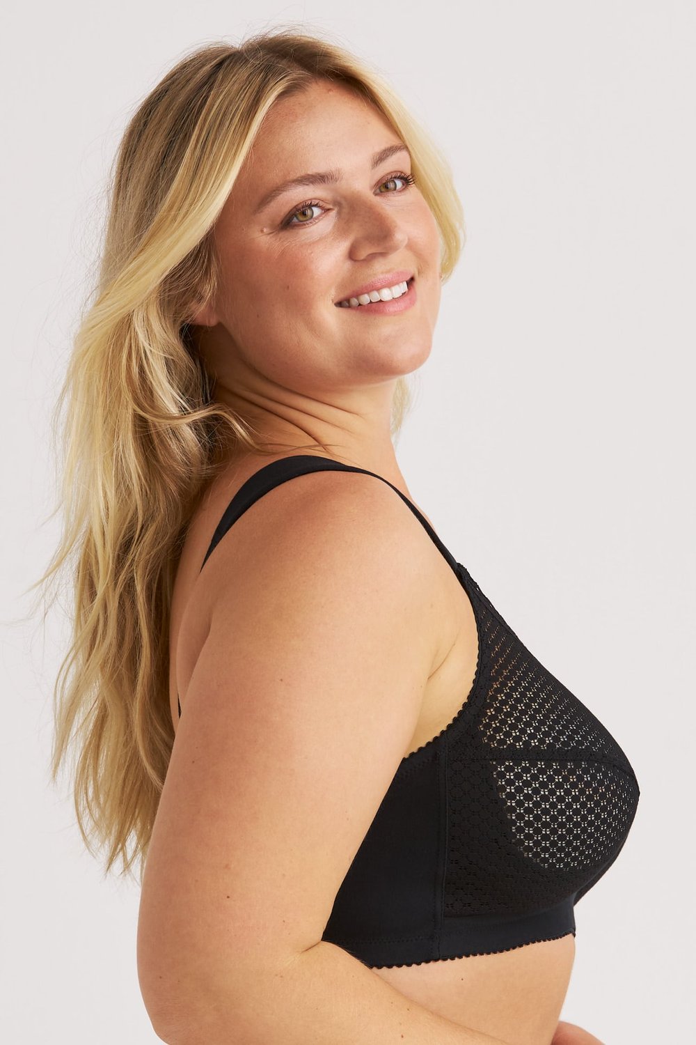 Profil d'une femme souriante portant le soutien-gorge sans armatures en coton noir Cotton Dots Comfort de Miss Mary.