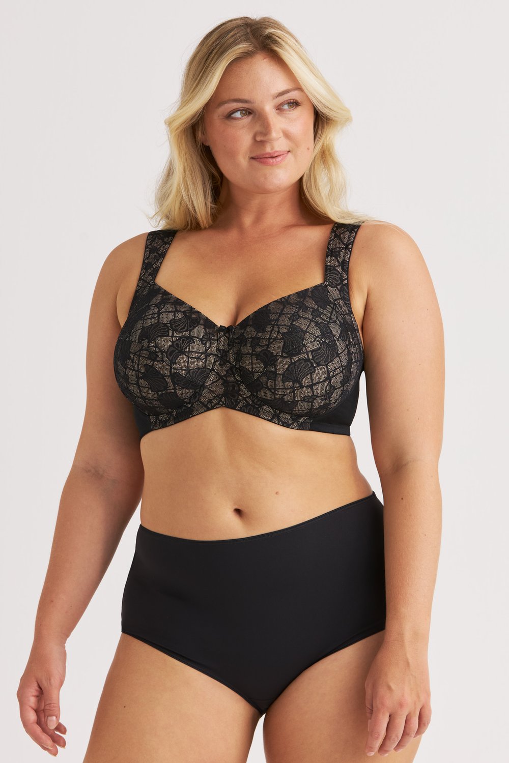 Frau trägt den schwarzen Lace Illusion Bügel-BH und den passenden Slip von Miss Mary.