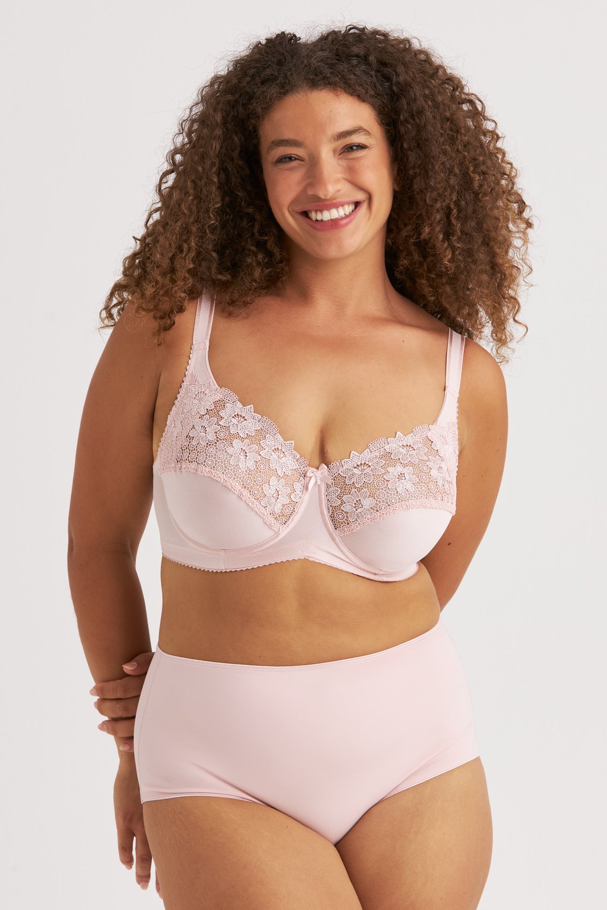 Femme souriante portant le soutien-gorge avec armatures vieux rose Summer de Miss Mary à broderie de guipure.