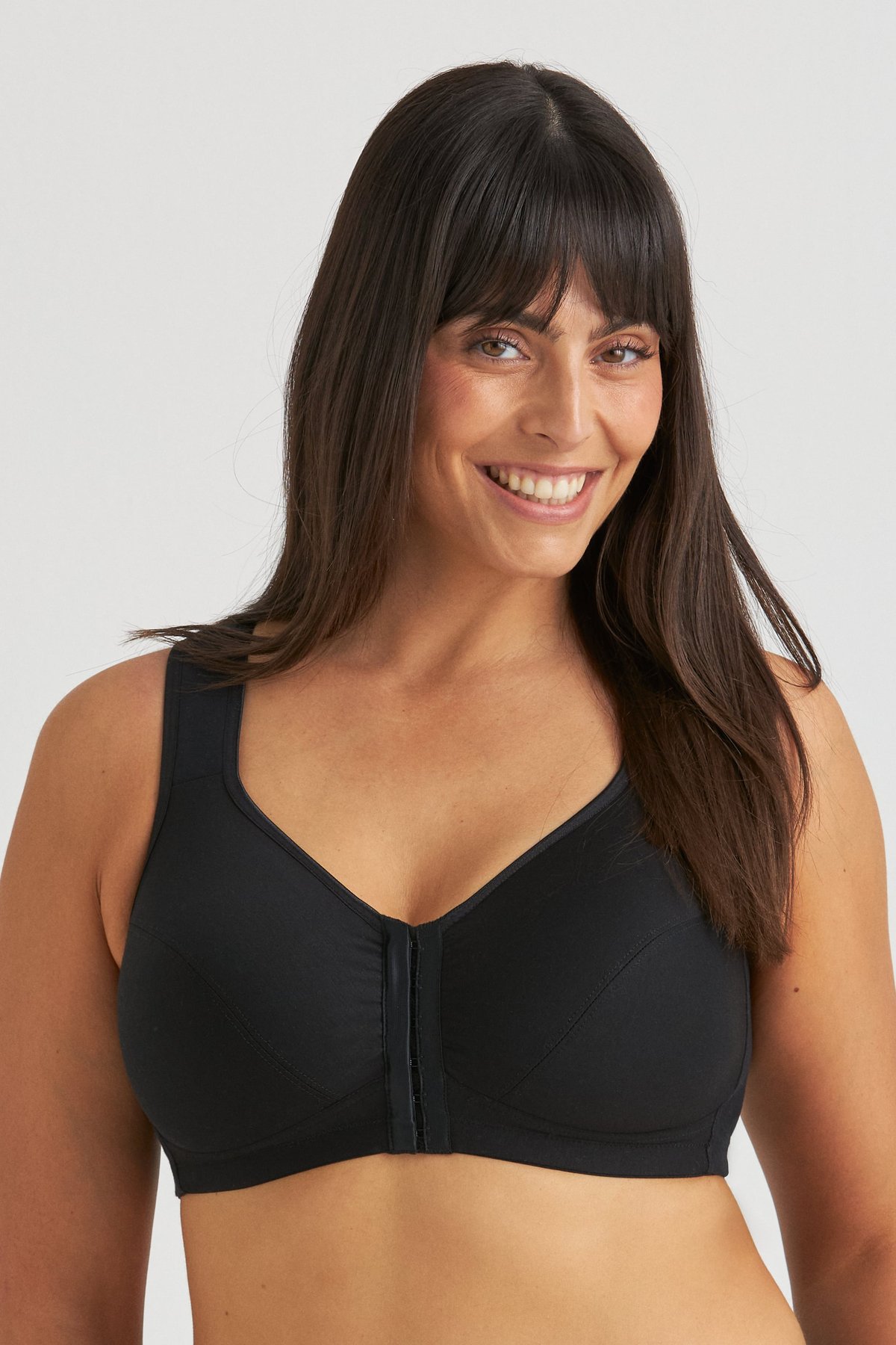 Femme souriante portant un soutien-gorge de maintien postural en coton sans armatures noir Miss Mary à fermeture devant.