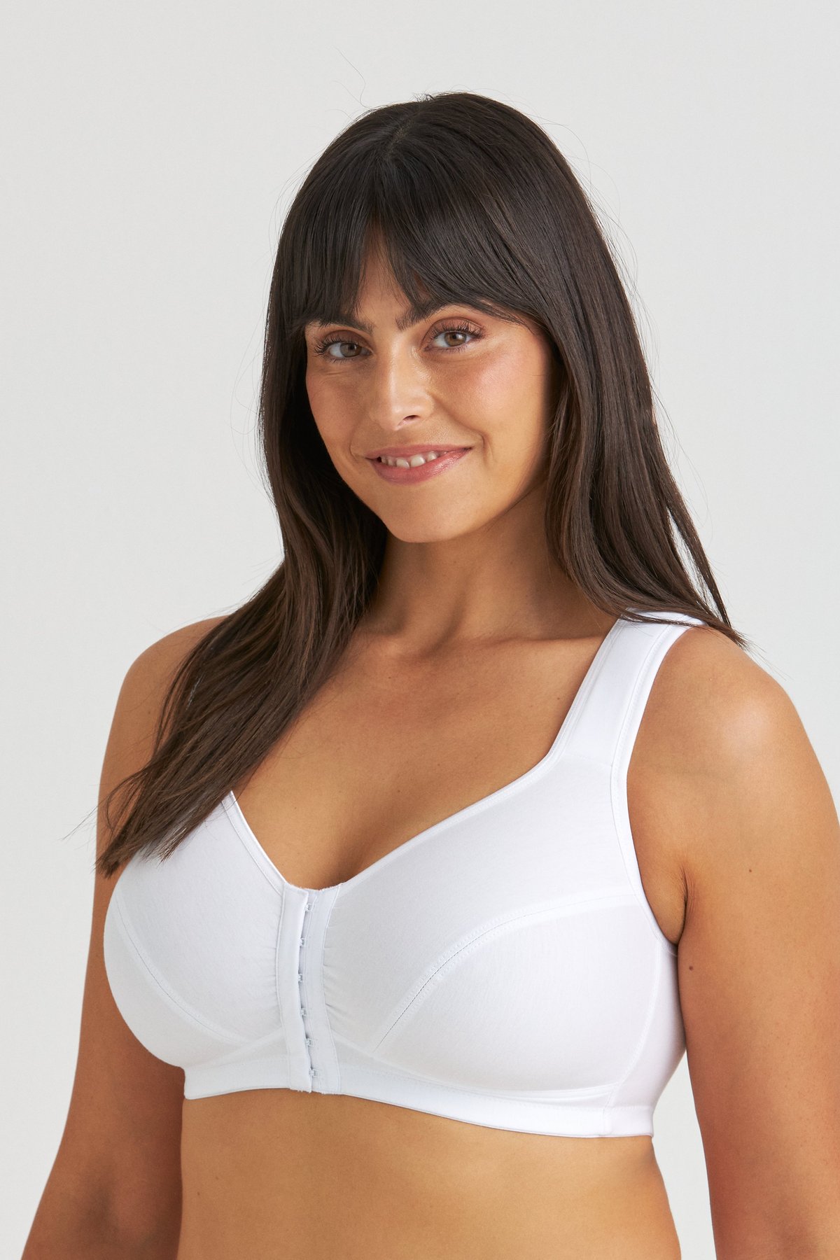 Femme souriante portant le soutien-gorge de maintien postural en coton blanc sans armatures Miss Mary avec fermeture devant.