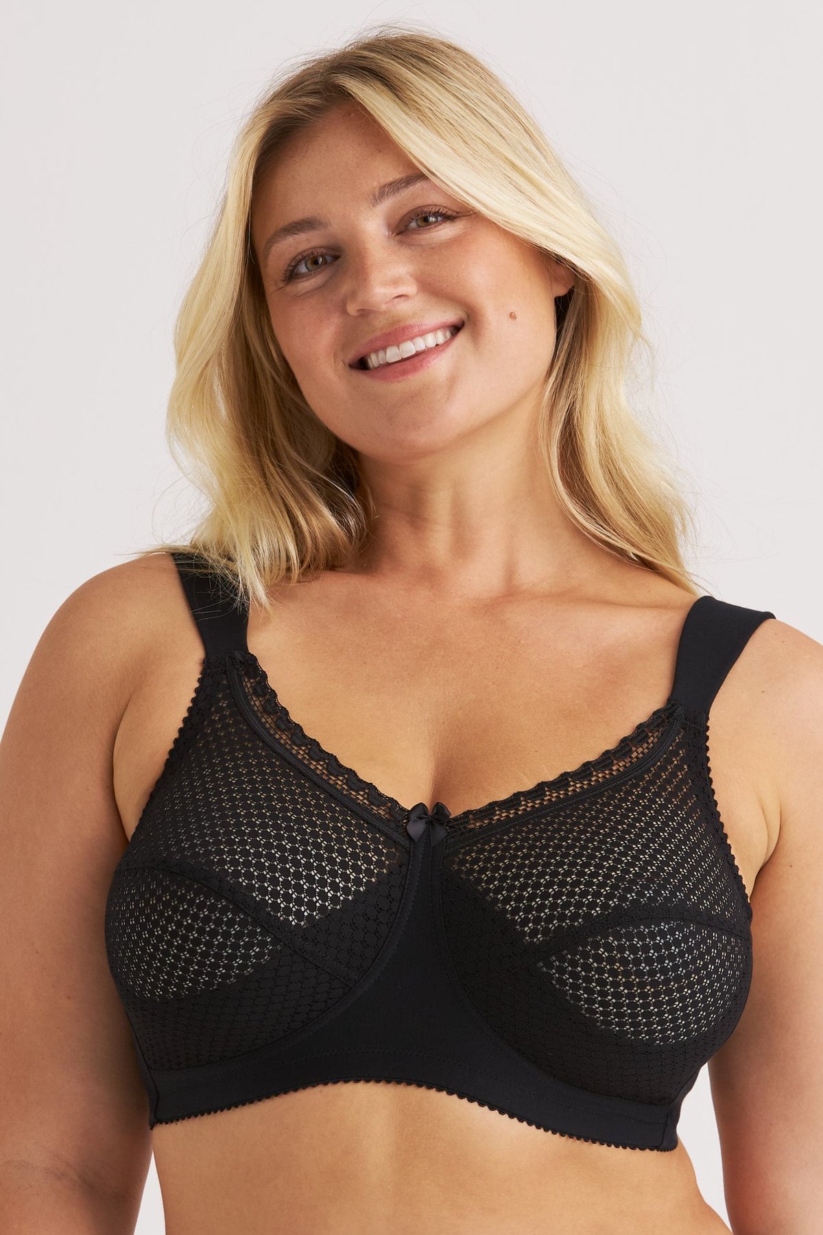 Femme souriante portant le soutien-gorge sans armatures noir Cotton Dots Comfort Miss Mary à larges bretelles.