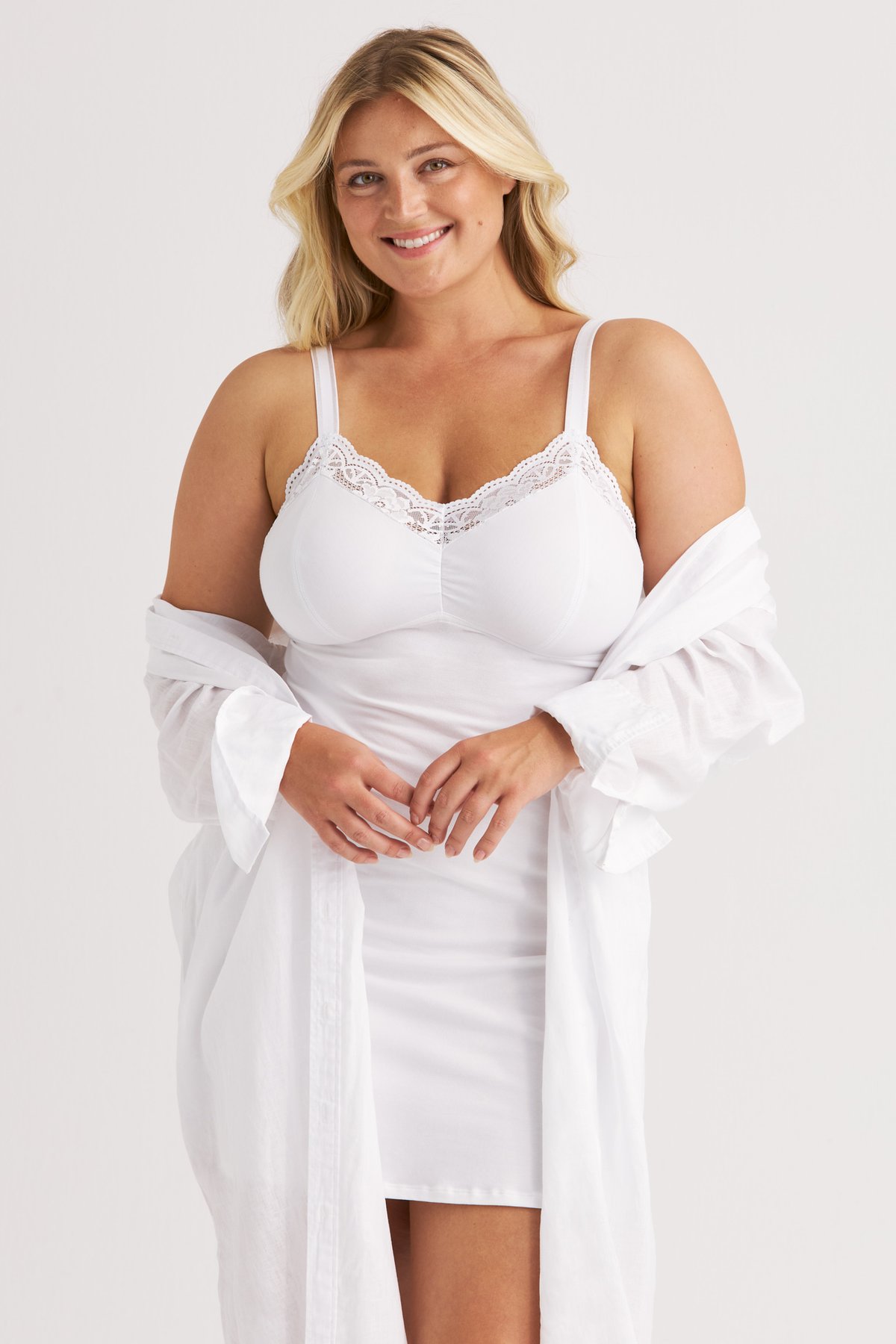 Femme souriante portant la nuisette blanche Lovely Lace Miss Mary avec bonnets de maintien en coton.