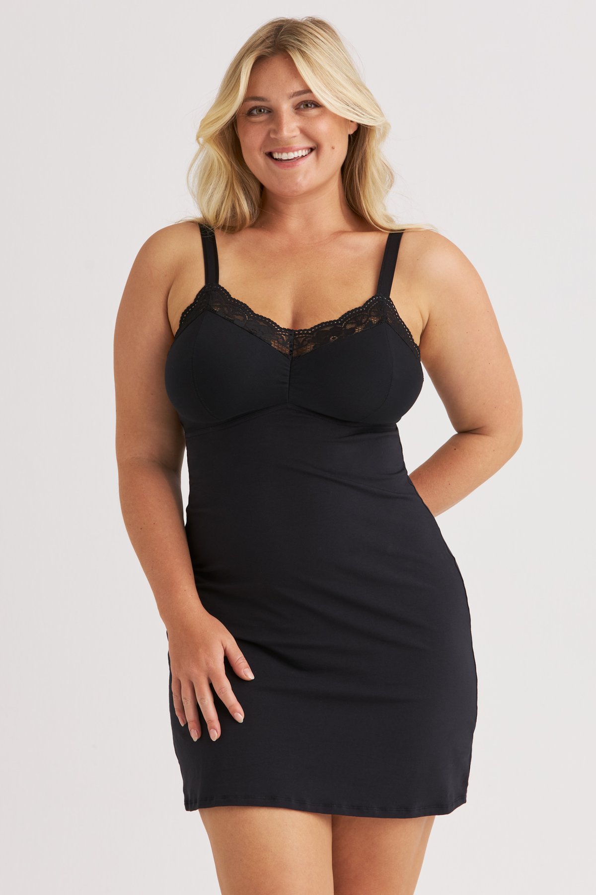 Femme souriante portant la chemise de nuit noire Lovely Lace Miss Mary à la bordure en dentelle délicate.