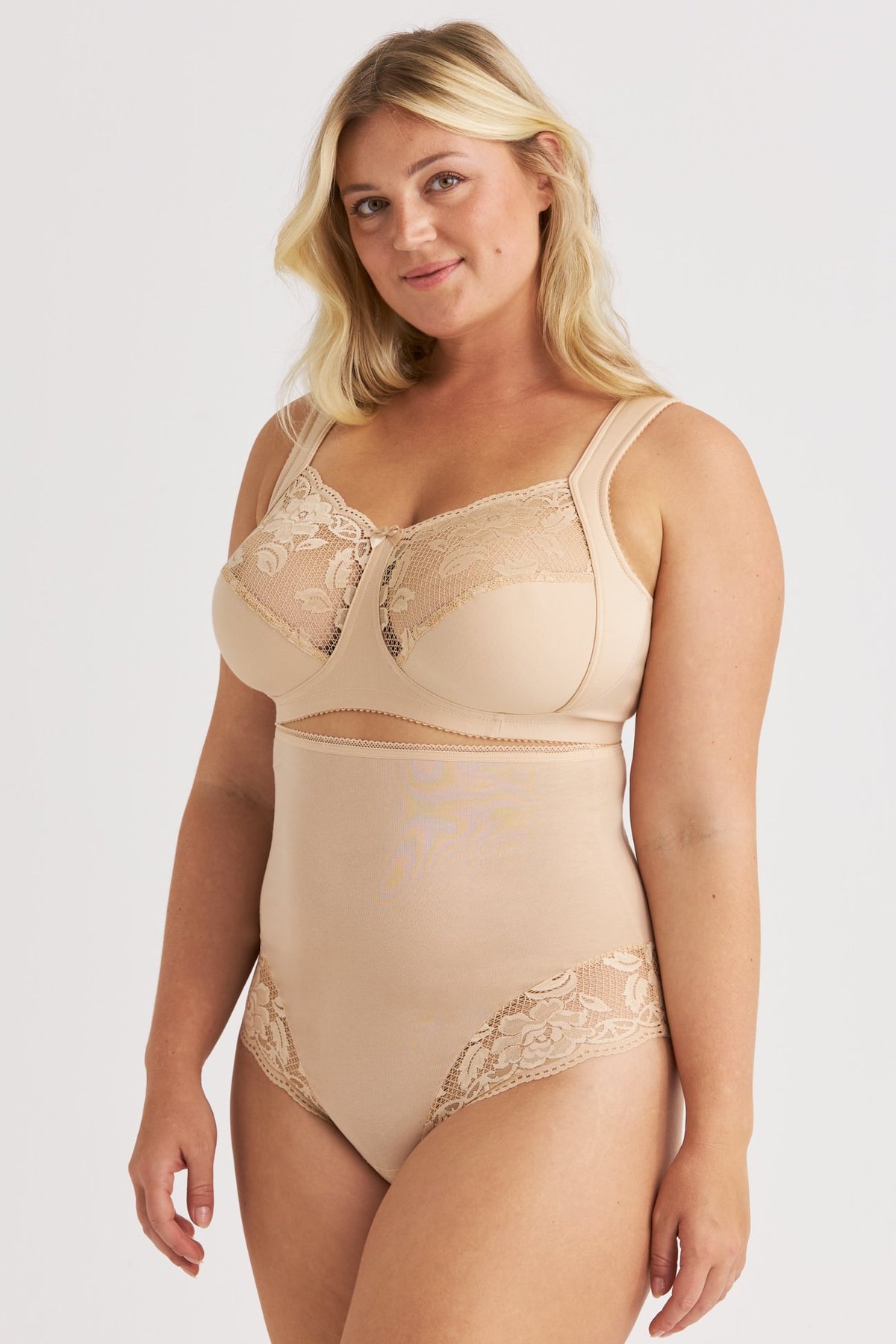 Femme portant le string taille haute beige Lovely Lace Miss Mary avec empiècements en dentelle et soutien-gorge assorti.