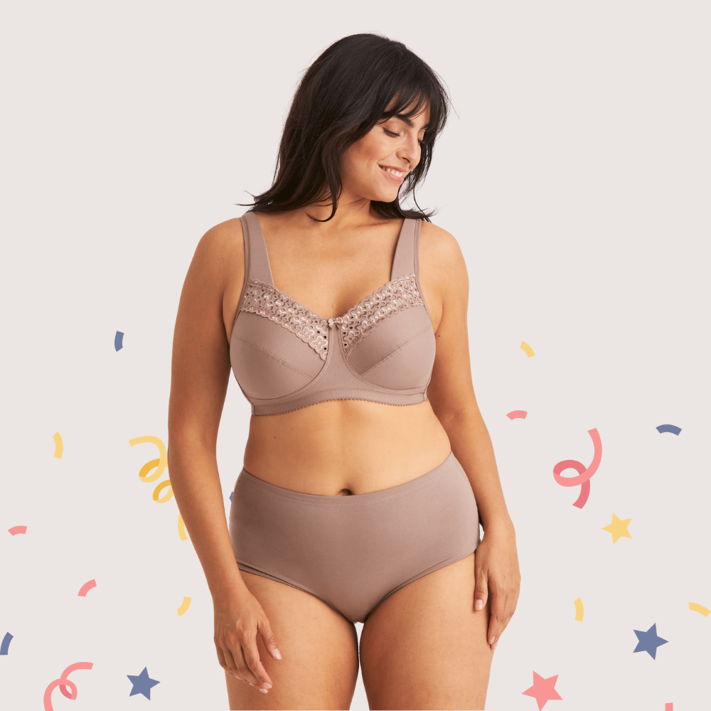 A woman smiling, wearing a matching beige bra and panties with lace details, standing against a light background with colorful decorative elements.