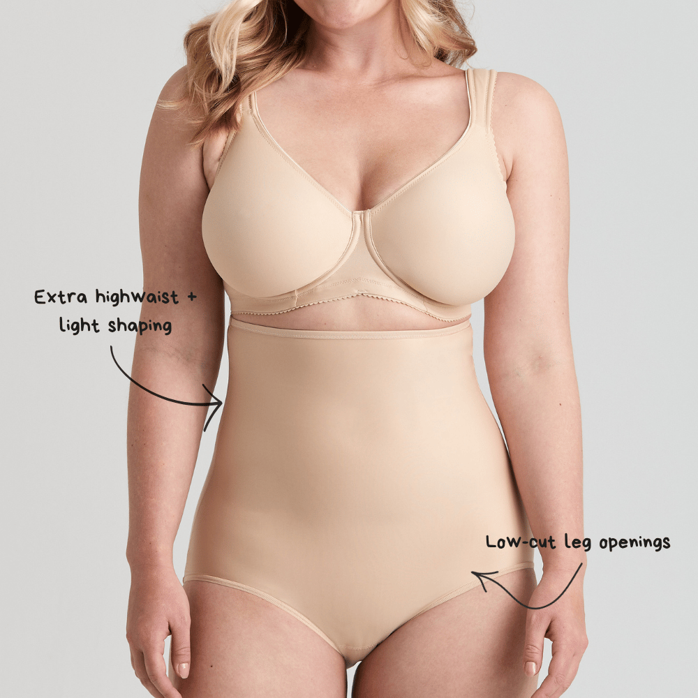 A person wearing beige shapewear with annotated features: "Extra high waist + light shaping" and "Low-cut leg openings."