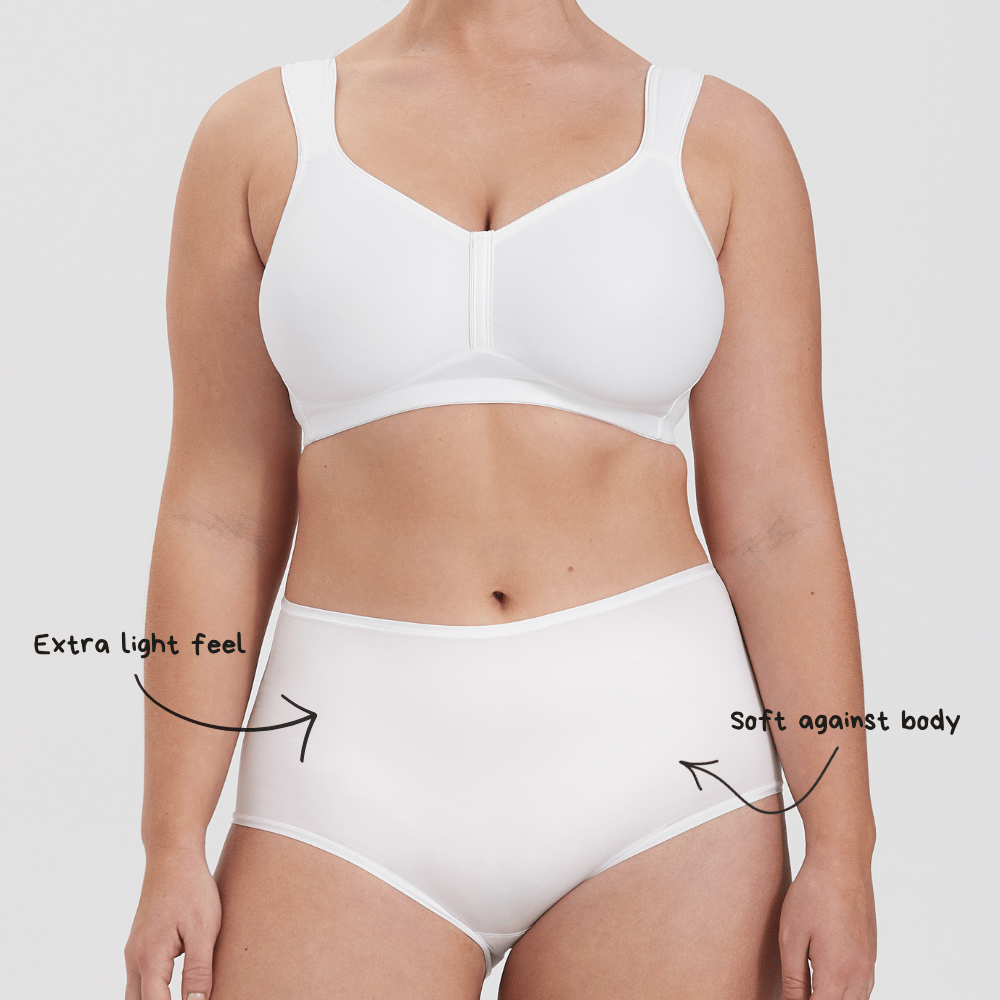 A person wearing a white bra and underwear, with text highlighting "Extra light feel" and "Soft against body."