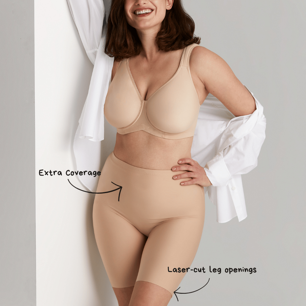 Woman in nude shapewear and bra, wearing an open white shirt. Text points to "extra coverage" and "laser-cut leg openings."