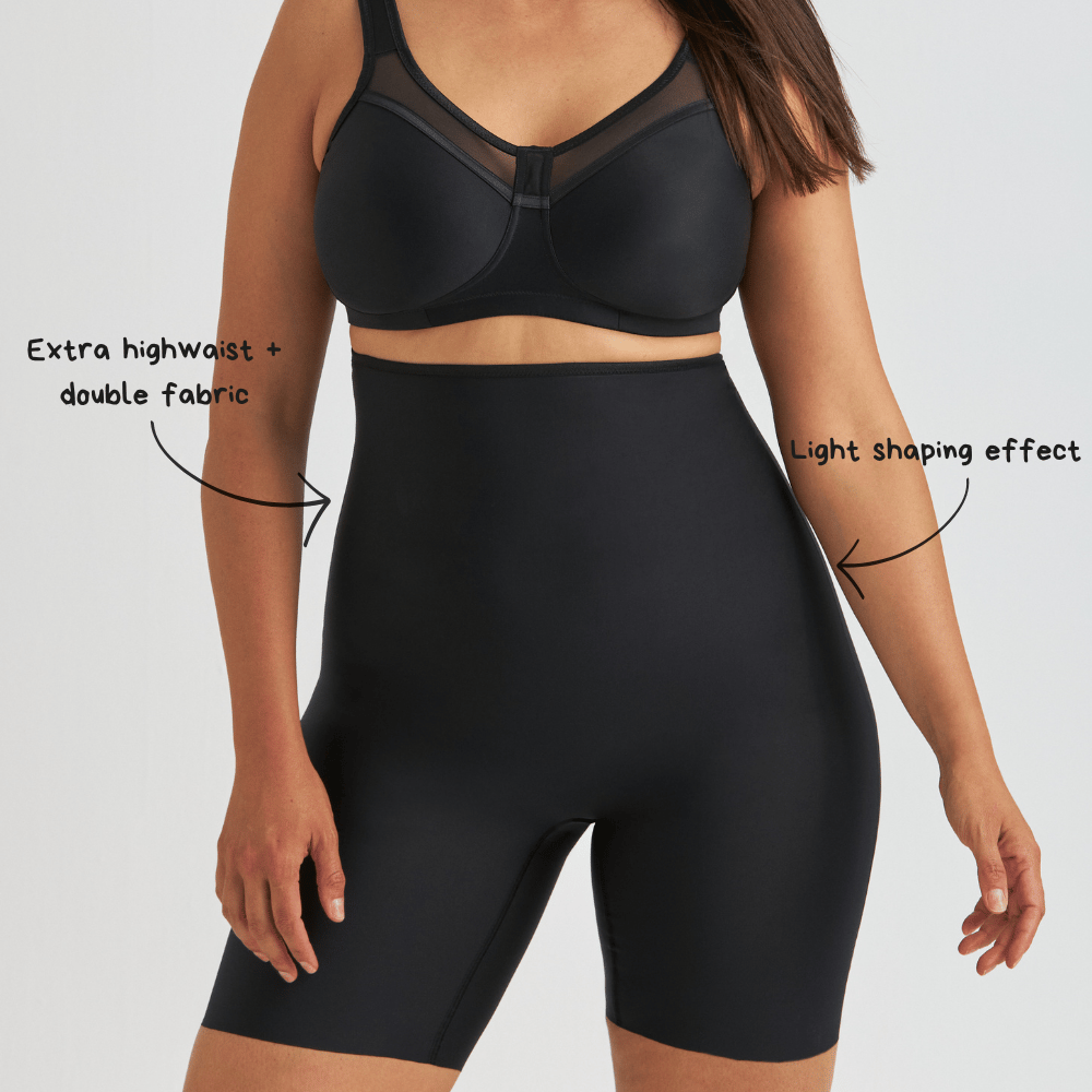 Person wearing black shapewear shorts and a bra, with text indicating features like extra high waist, double fabric, and light shaping effect.